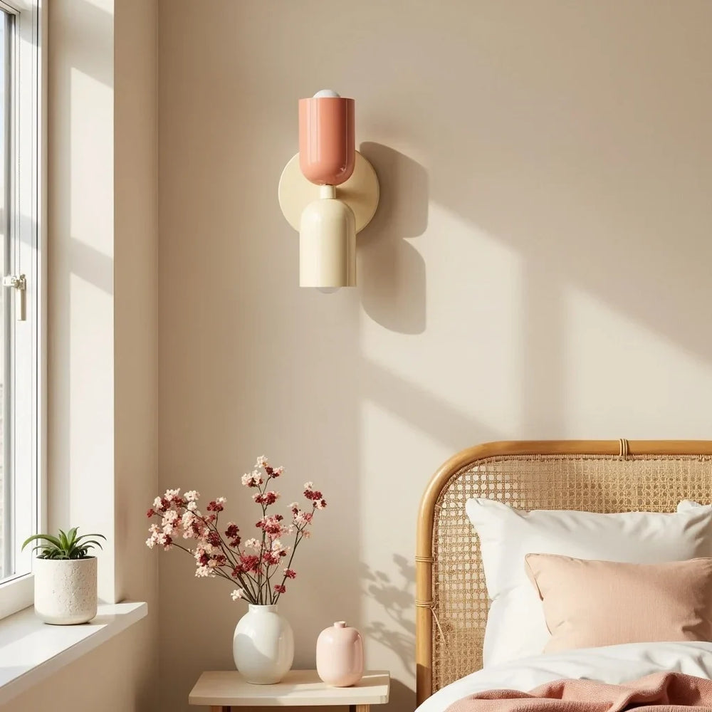 Retro wall lamp in coral and cream on a beige wall beside a rattan headboard
