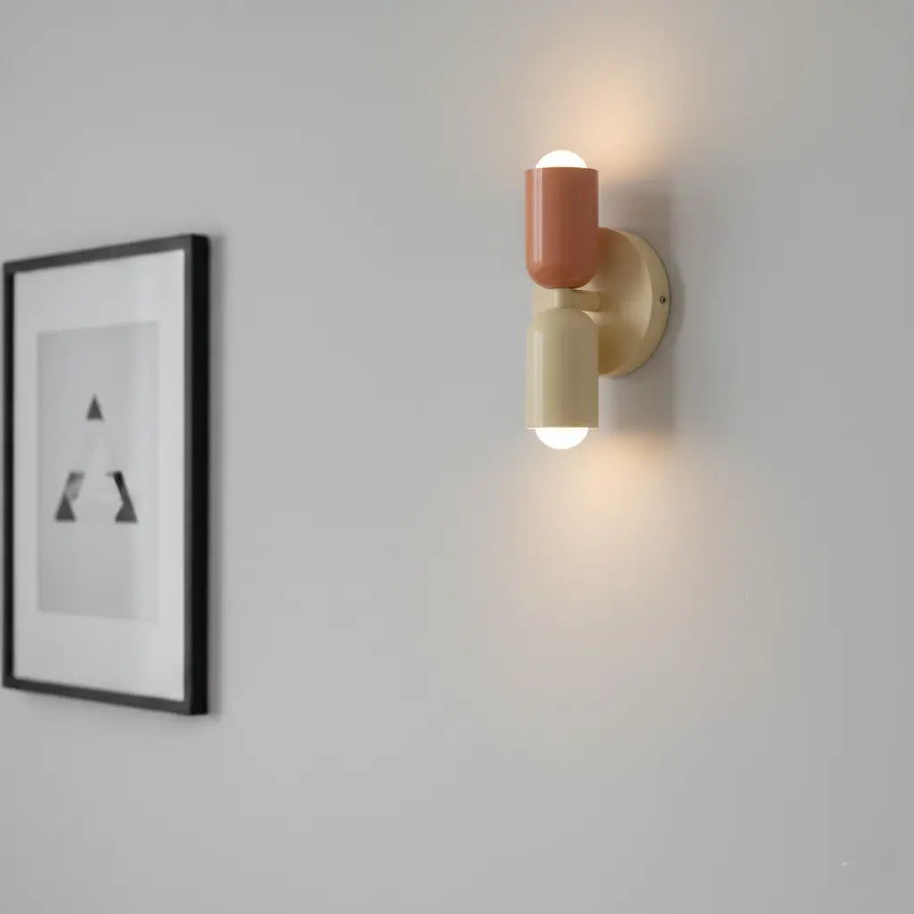 Retro wall lamp detail in coral and cream on a pale gray wall