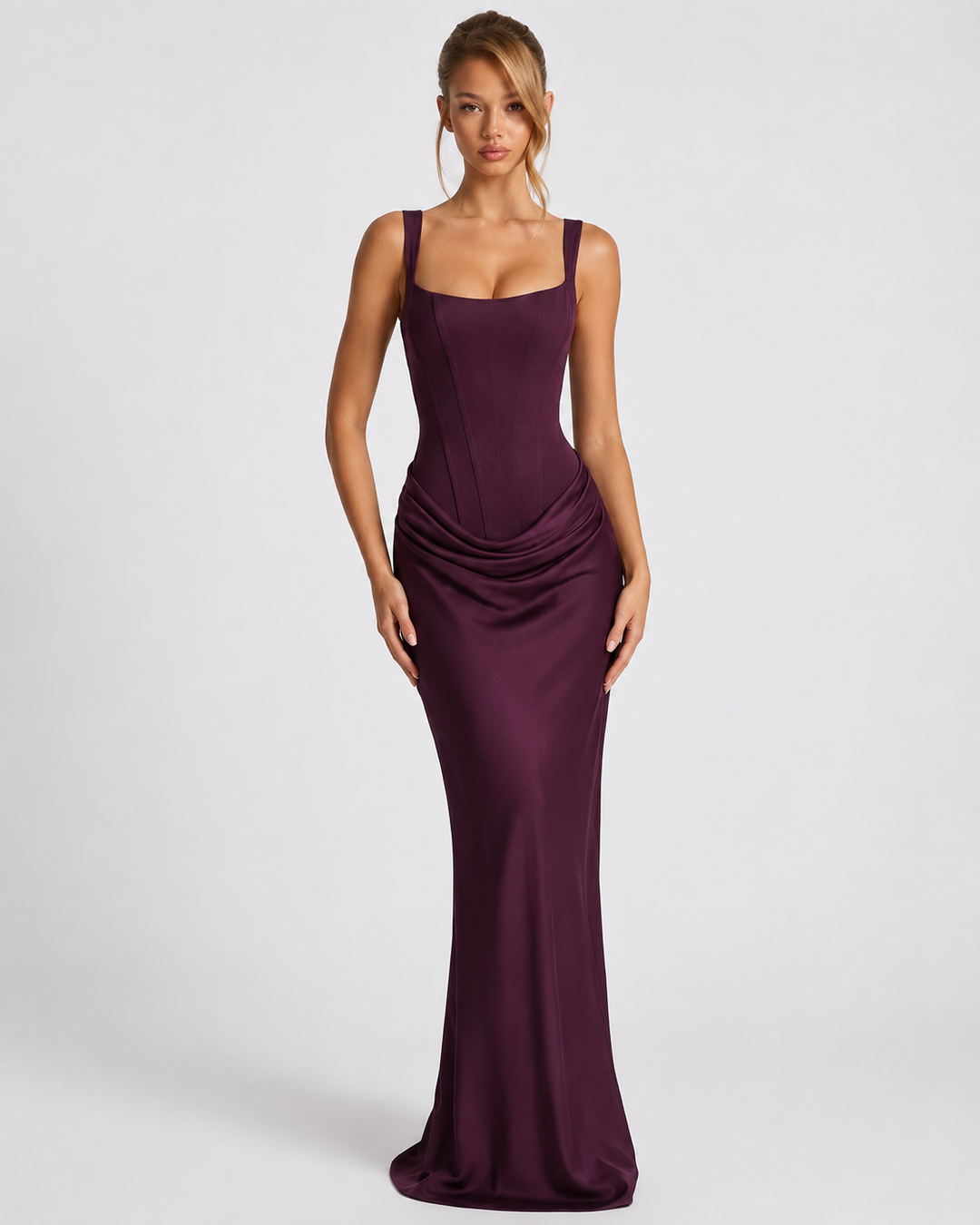 Dark plum satin maxi dress with a seamed corset bodice and draped hip, front view.