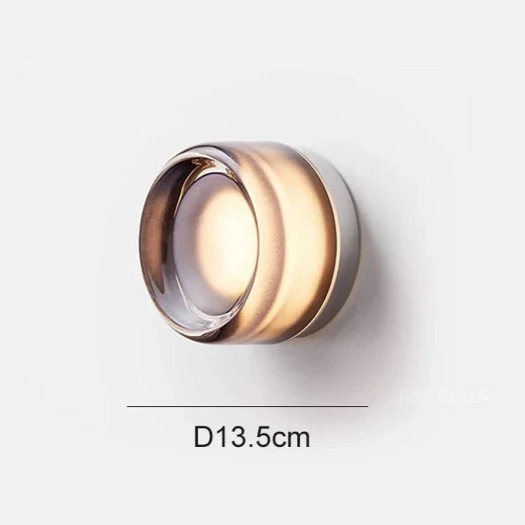 Smoky gray glass round wall light shown lit on a white background with a 13.5 cm diameter line.
