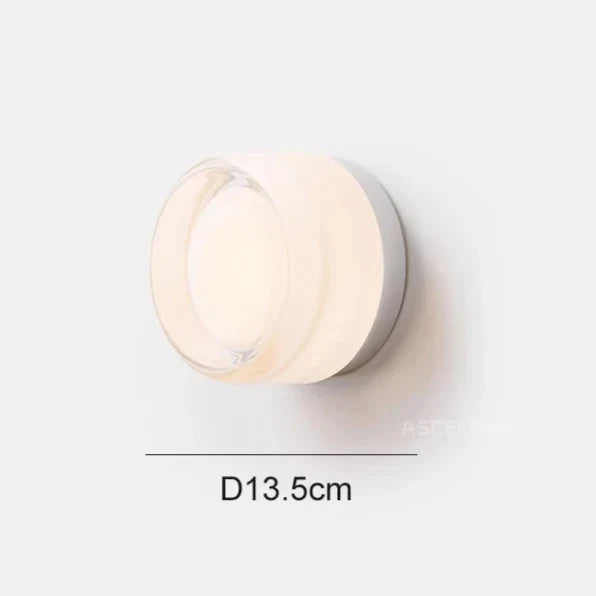 Clear frosted glass round wall light shown lit on a white background with a 13.5 cm diameter line.