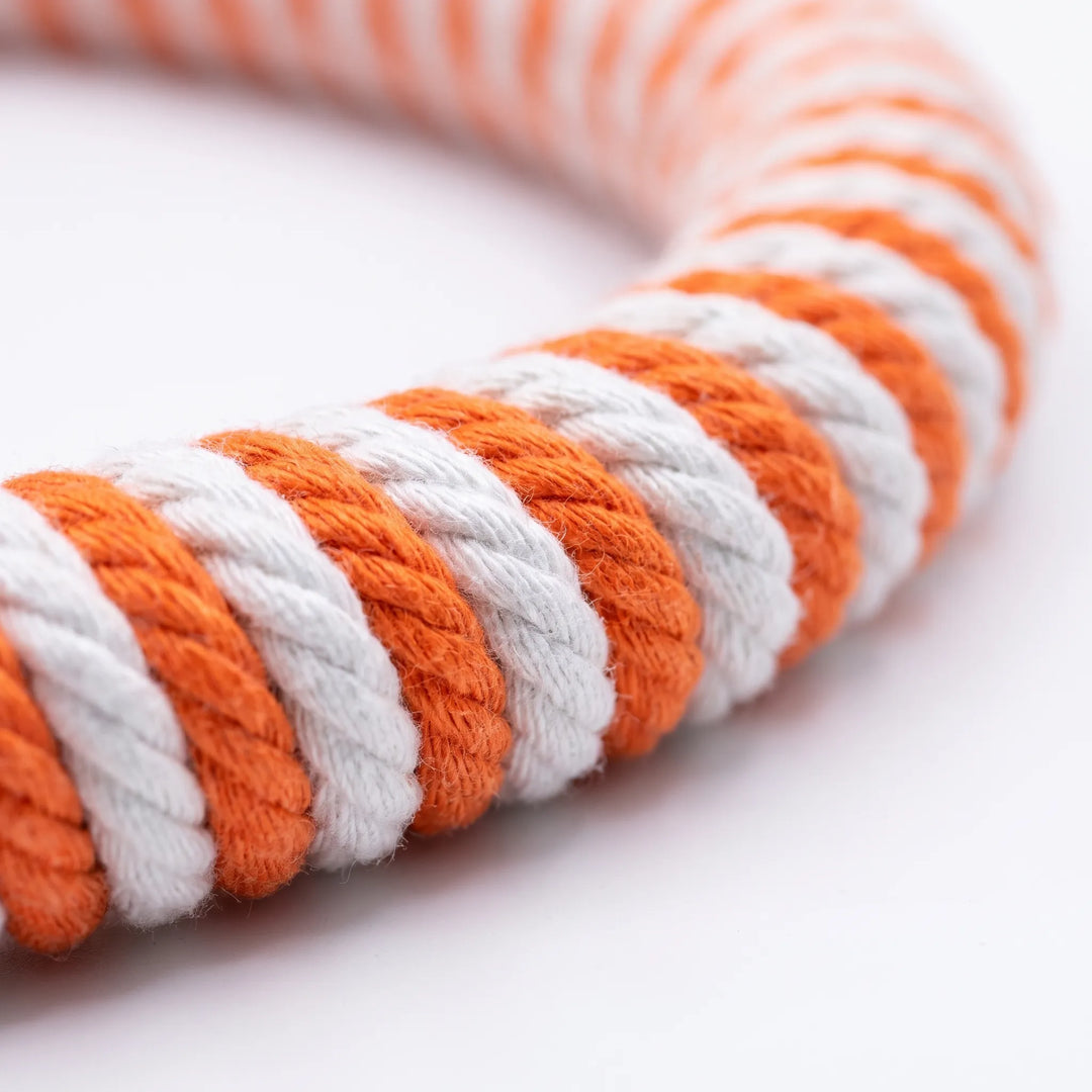 Close-up of the twisted orange and white cotton rope wrapped around the ring, showing the braided texture of each stripe. 3