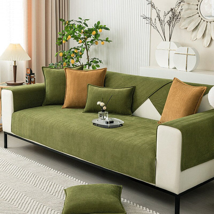 Green chenille sofa covers on a cream sofa with green and mustard cushions.