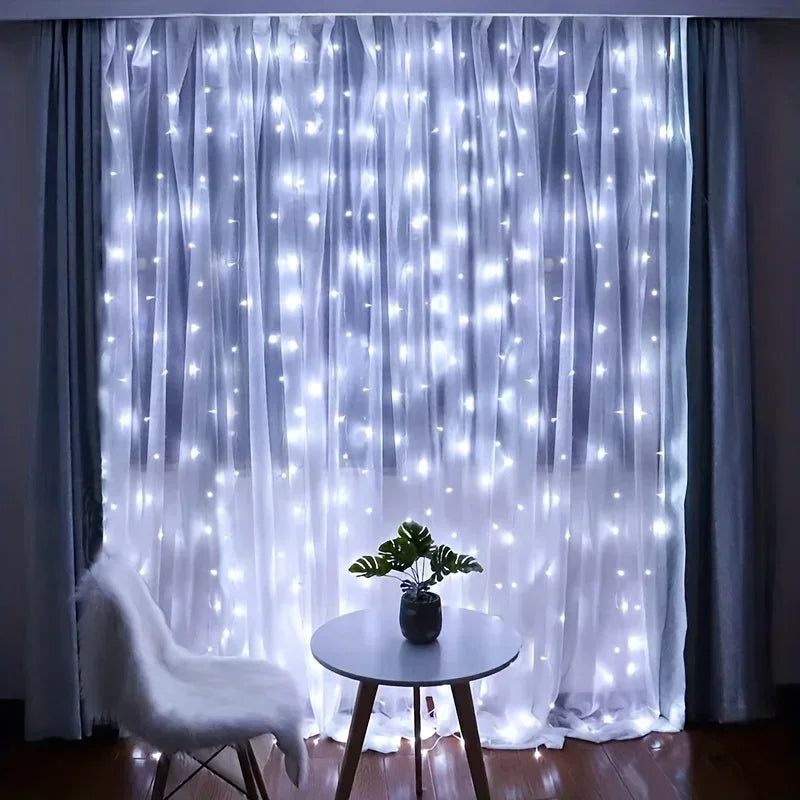 Cool white curtain lights glowing behind sheer curtains in a living room, with a small round table and a plant in front. 4