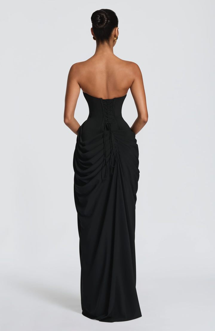 Back view of the black strapless dress showing corset lace-up closure with loose ties and gathered draping. 33