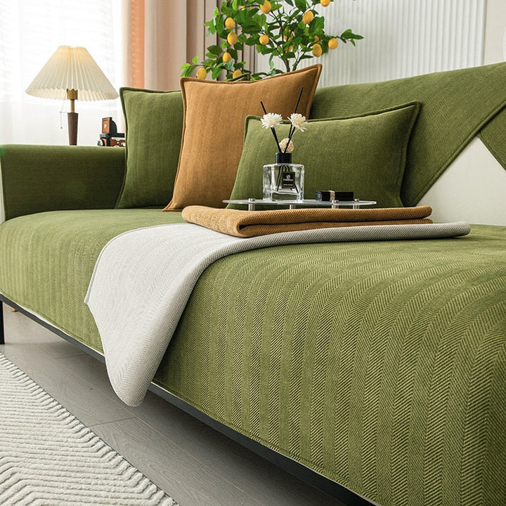 Olive green chenille sofa cover with one corner folded back to show its light gray underside.
