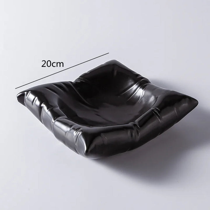 Empty black cloud-shaped porcelain bowl, showing its glossy pleated sides.