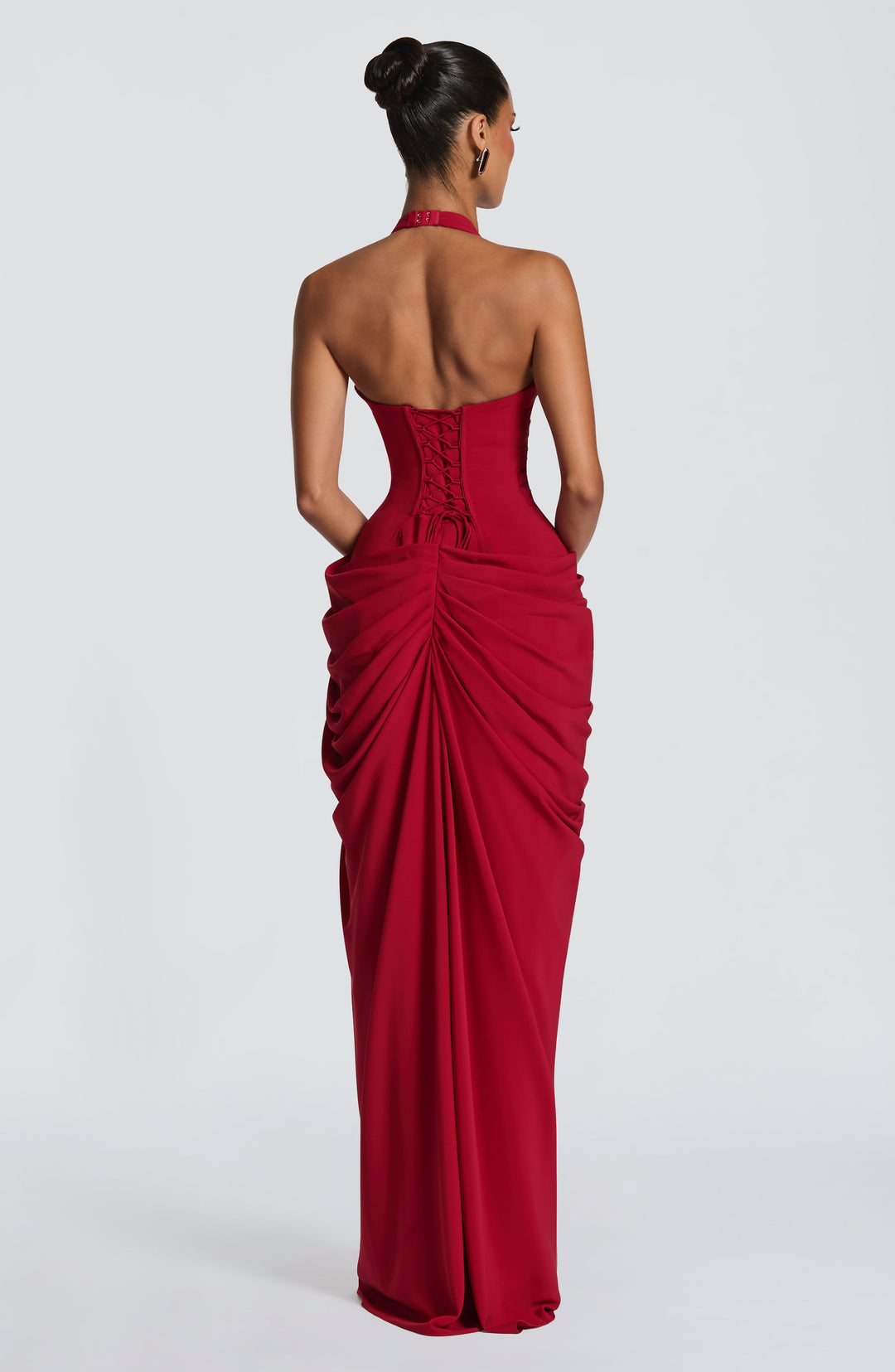 Deep red halter maxi dress detail showing the lace-up corset back, halter clasp and gathered chiffon skirt.