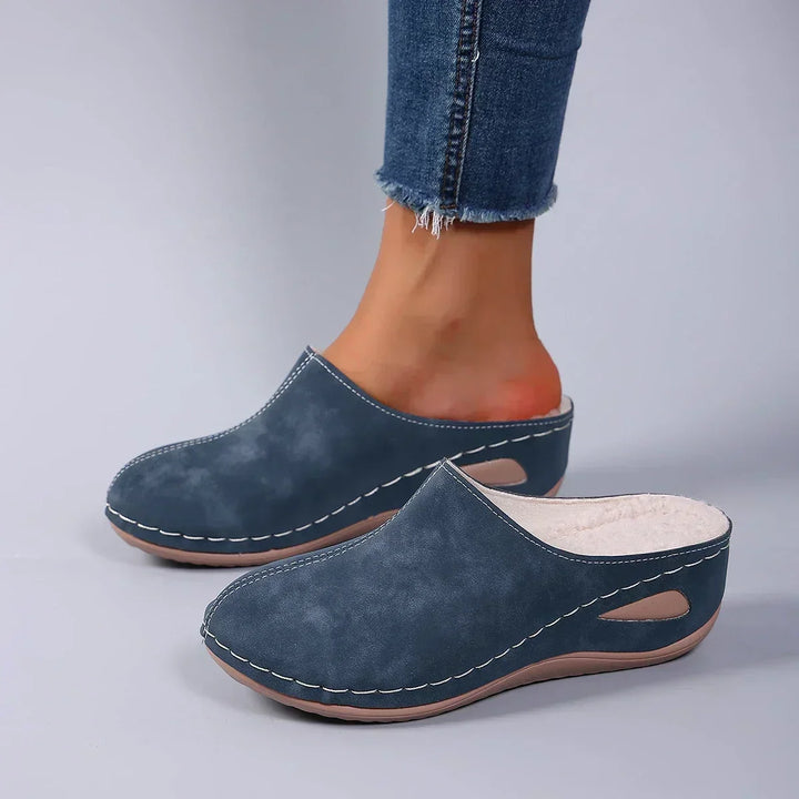 Blue backless clog slippers with the soft fleece lining visible, another view.