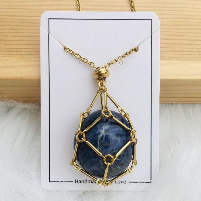 Gold cage necklace with a round deep blue stone with white veining on a white card. 12
