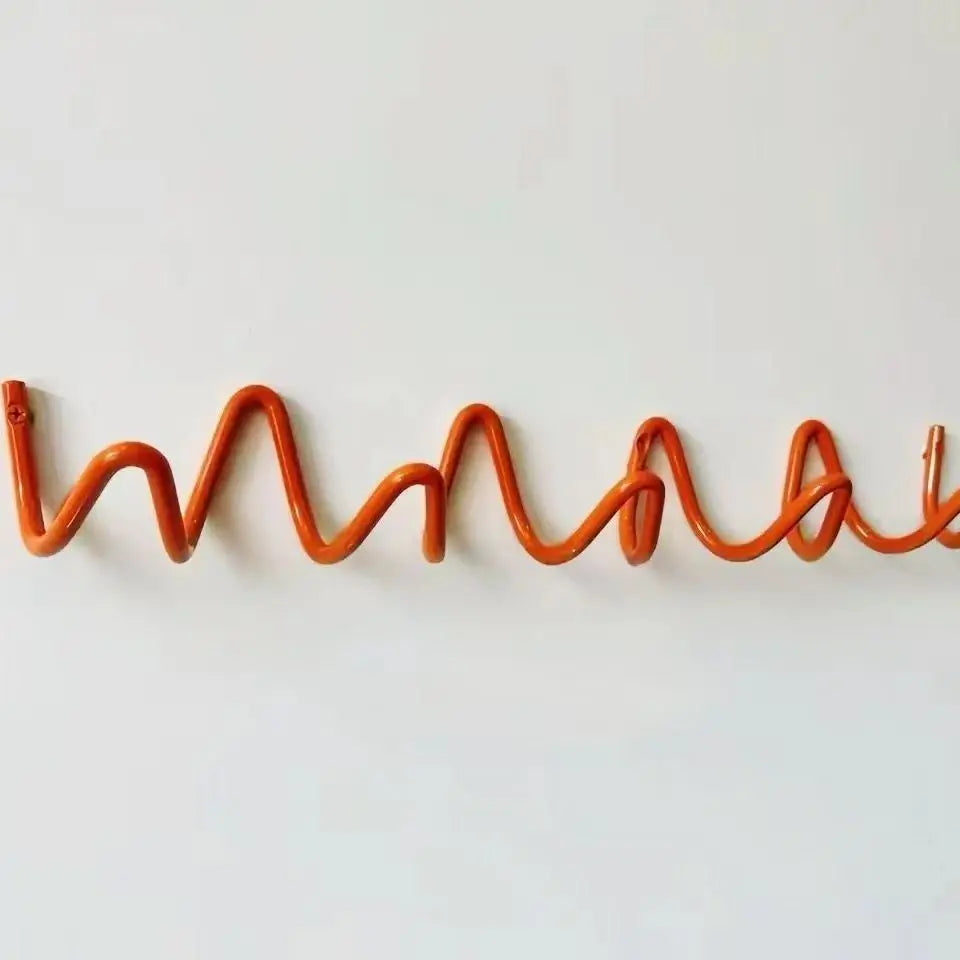 Silver metal wall rack detail mounted on a white wall.