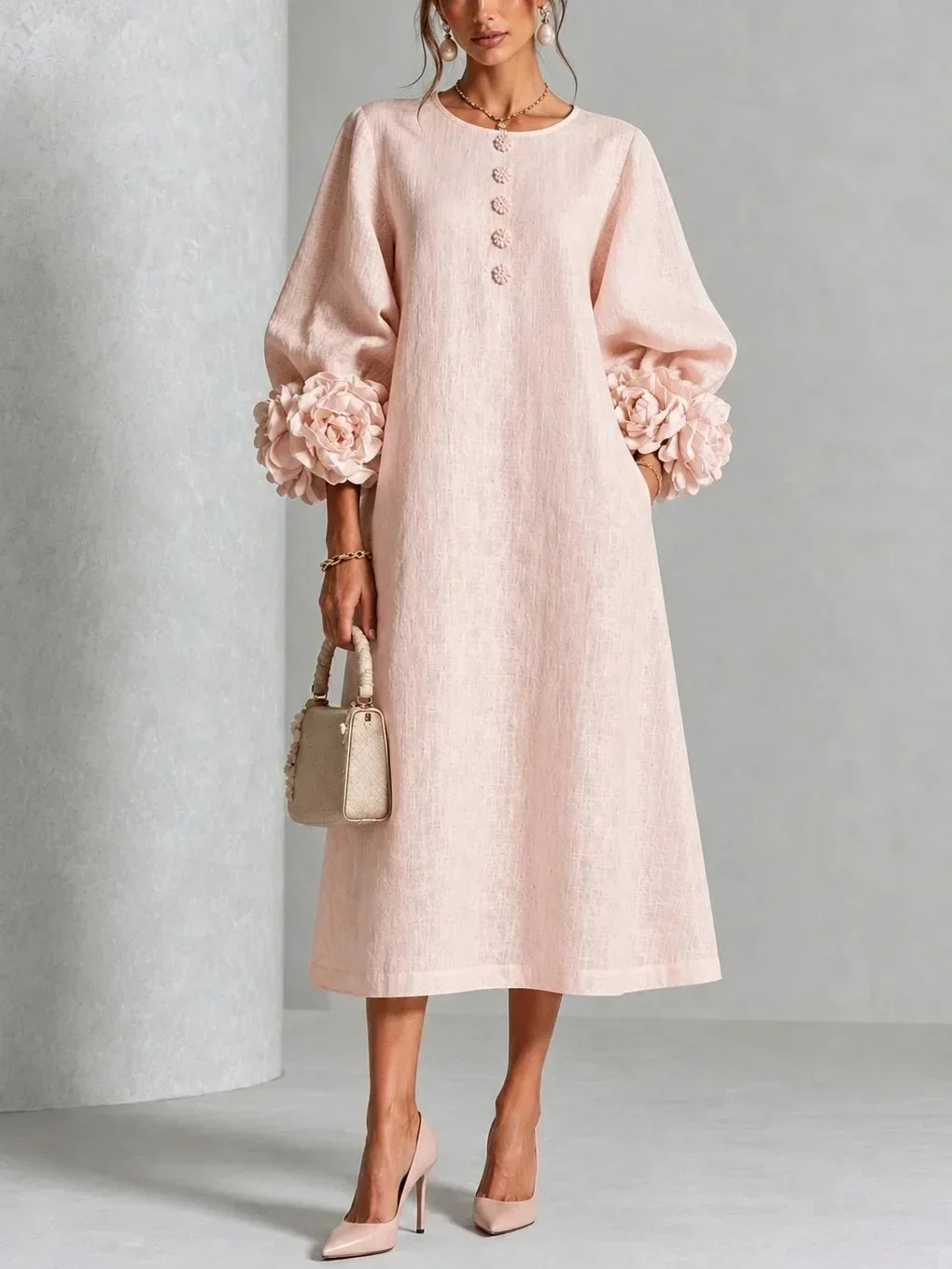 Model wears the blush pink version of the midi dress with floral buttons, rose cuffs on the puffed sleeves and pink heels. 4