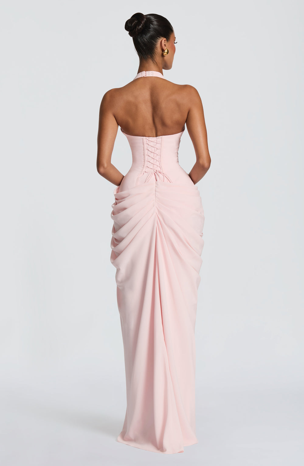Pale pink halter maxi dress detail showing the lace-up corset back, halter clasp and gathered chiffon skirt.