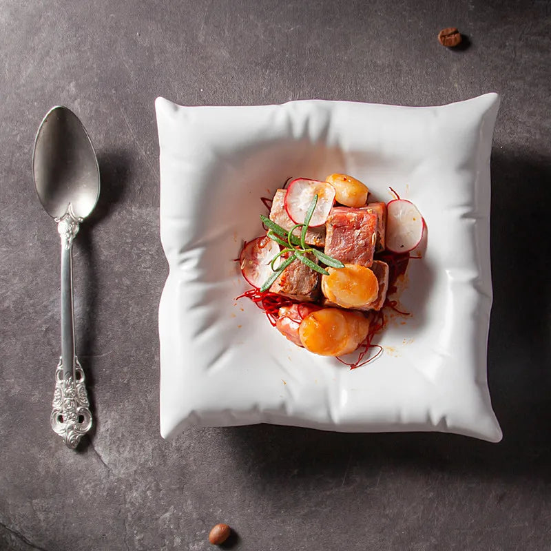 White bowl detail with a puckered rim, filled with meat, radish and orange pieces.