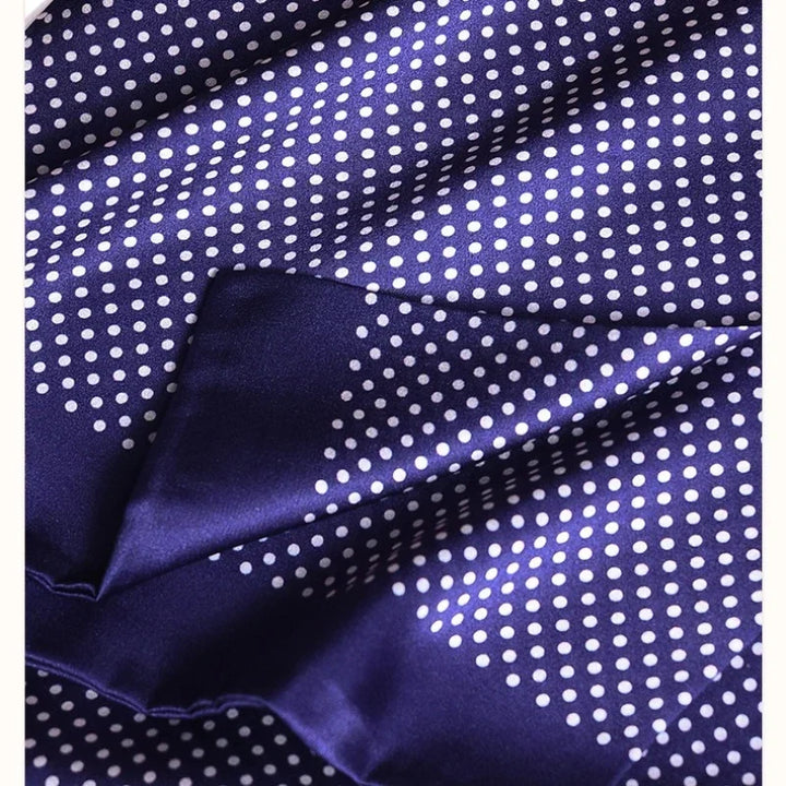 Close-up of the folded double-layer navy silk fabric with white polka dots and a smooth, glossy sheen. 27