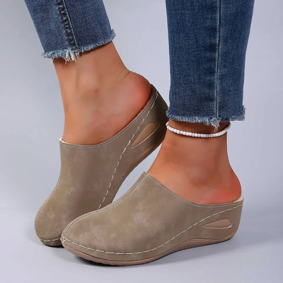 Taupe wedge-sole clog slippers with tonal stitching and a side cutout, another view.