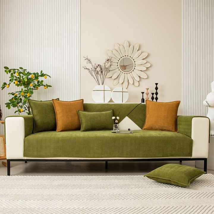 Full front view of a cream sofa dressed in green chenille covers with mustard cushions.