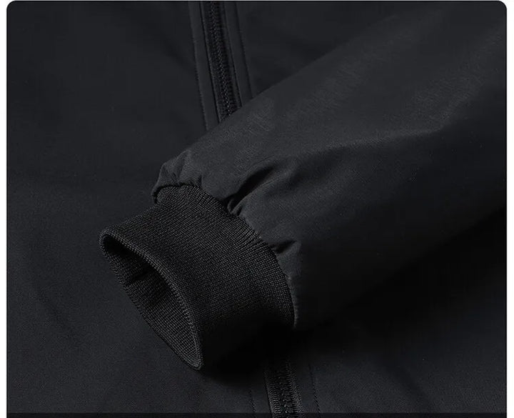 Close-up of the black jacket's ribbed knit cuff at the sleeve opening, with gathered fabric above it. 8