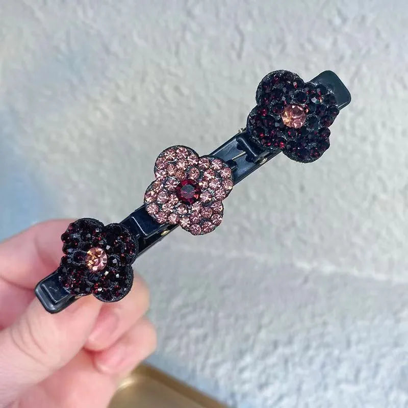 Hand holding a black clip with three dark burgundy and dusty pink rhinestone flowers 4