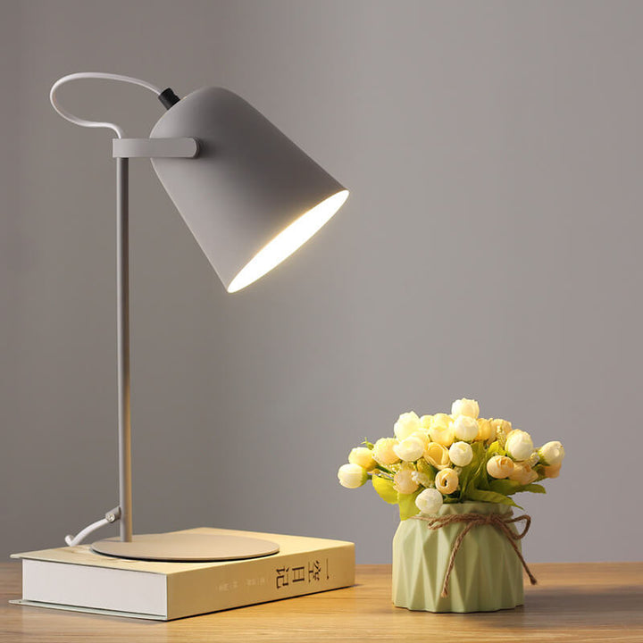 Light gray version of the lamp glowing on a book beside a small vase of flowers 10