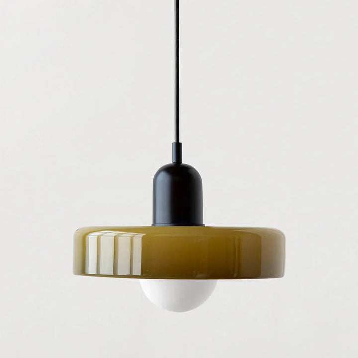 Olive glass disc shade paired with a matte black capsule cap and black cord, frosted globe bulb underneath. 23