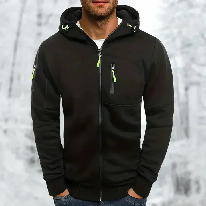 Man wearing the black zip-up hoodie with lime green zipper pulls and drawcords, with a zip chest pocket and sleeve pocket.