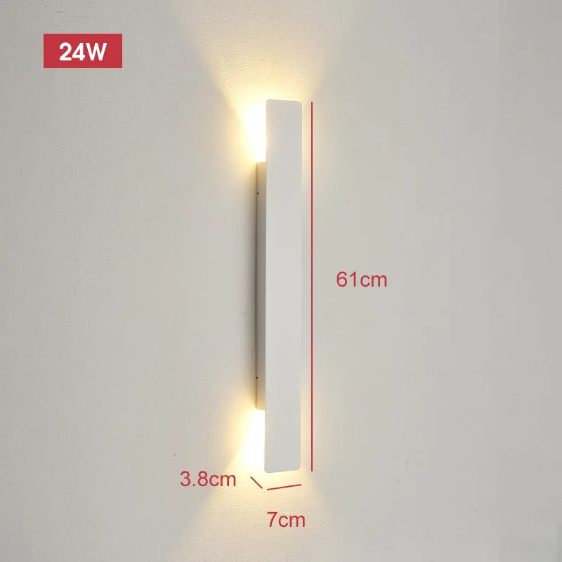 Longer white wall light on a wall emitting warm light from both ends, with dimension lines showing its size.