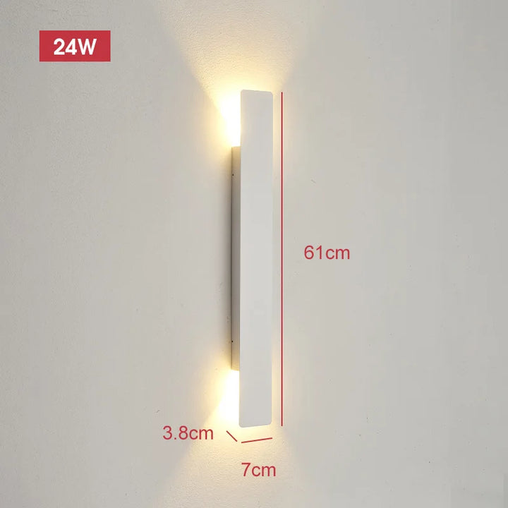 Longer white wall light on a wall emitting warm light from both ends, with dimension lines showing its size.