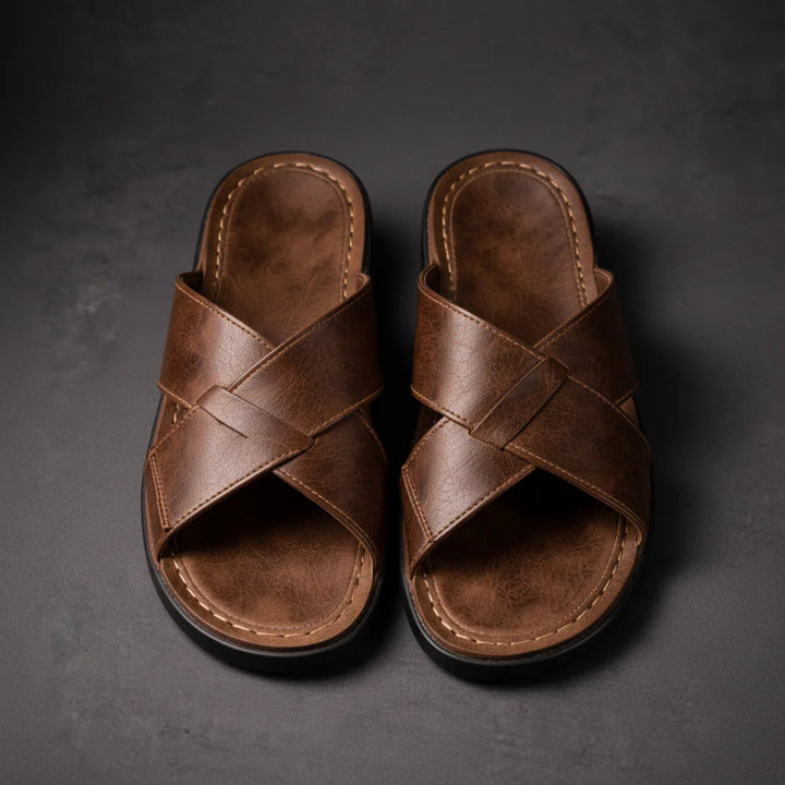Top-down view of a pair of brown crossed-strap sandals side by side, showing the stitched footbeds and woven strap detail. 4