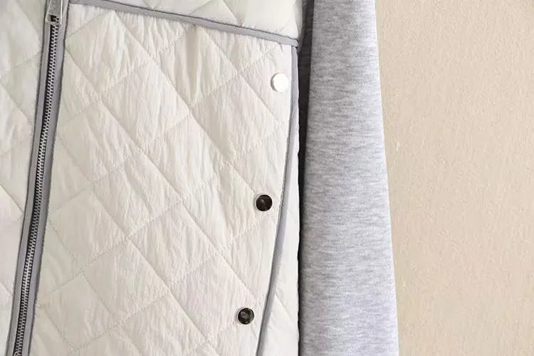 Weiße gesteppte Jacke mit silbernem Reißverschluss und grauem Futter, modisch und warm.