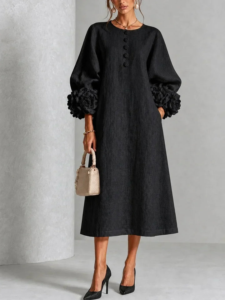Model wears the black version of the midi dress with floral buttons, oversized rose cuffs on the puffed sleeves and black heels. 5
