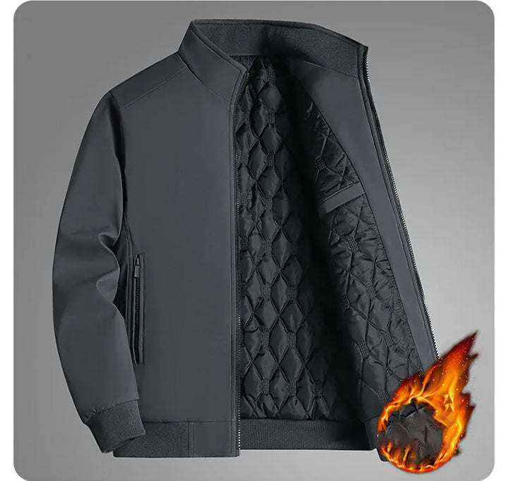 Gray jacket unzipped on a gray backdrop, showing the black quilted lining and zippered side pocket, with a flame graphic for warmth. 11