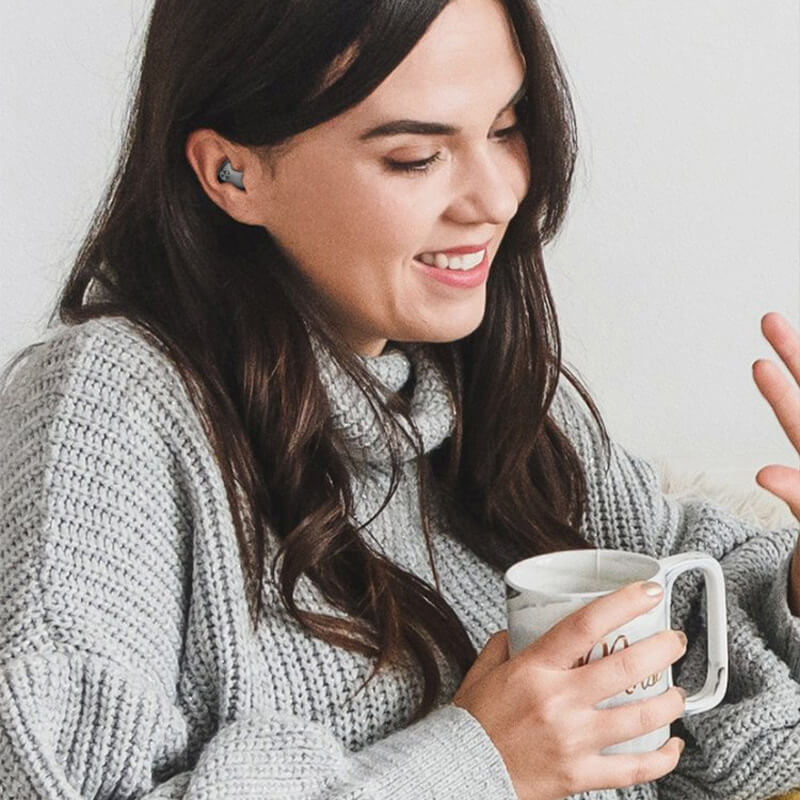 Woman wearing a black in-ear sleep earbud, another view.