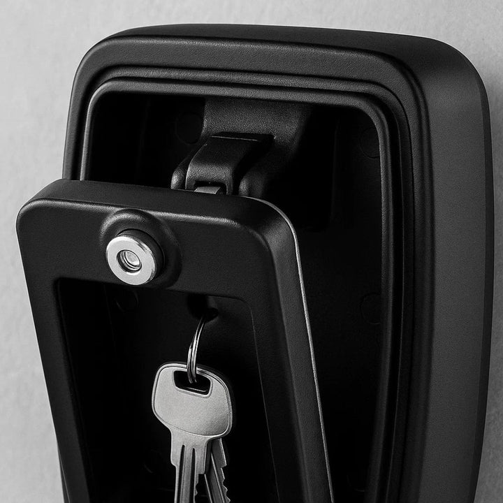 Black and white close-up of the opened key safe, showing the keyhole on the inner cover and keys hanging below. 4