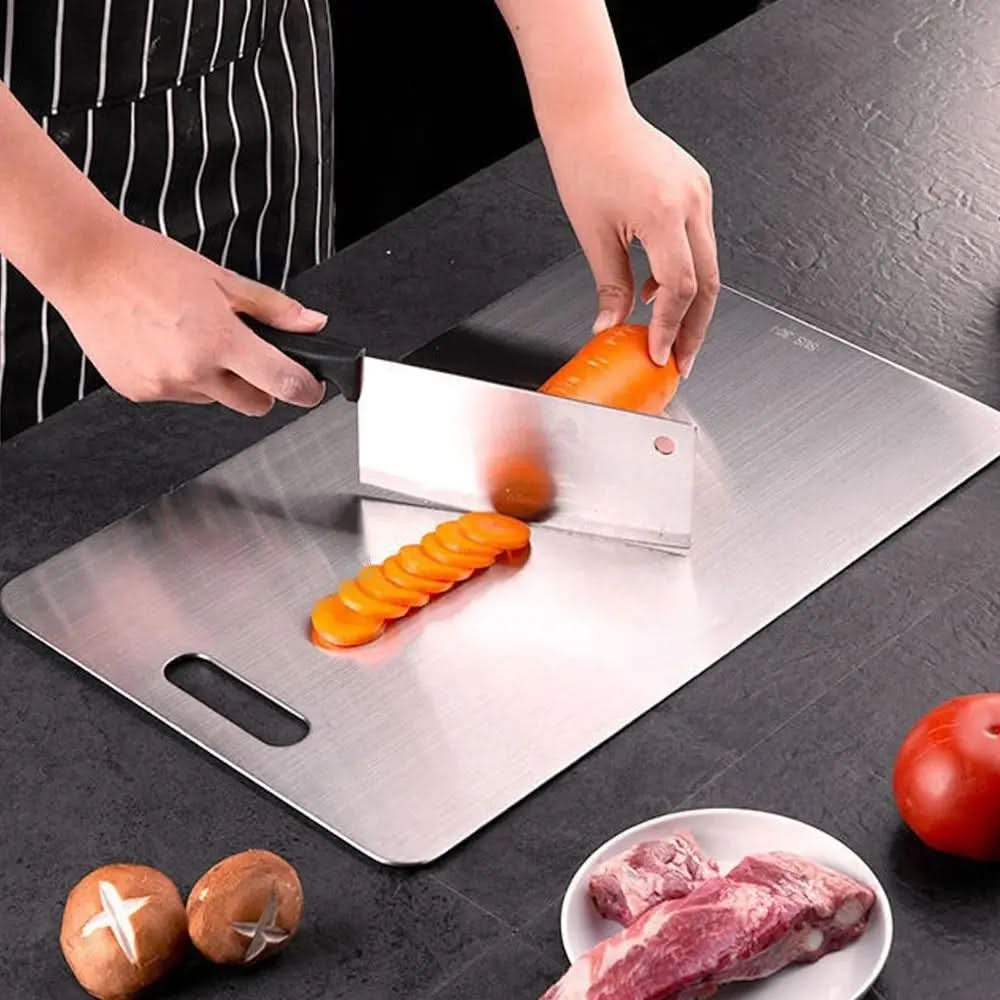 Cleaver slicing a carrot into rounds on the board, with mushrooms, a tomato and a plate of raw meat nearby. 3