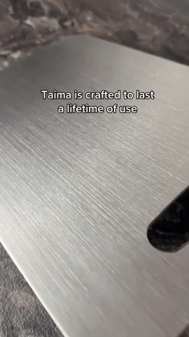 Close-up of the brushed metal surface with fine linear grain and the edge of the handle cutout. 8
