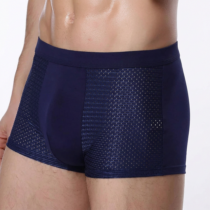 Torso of a model wearing navy boxer briefs with breathable mesh side panels and a wide waistband 5
