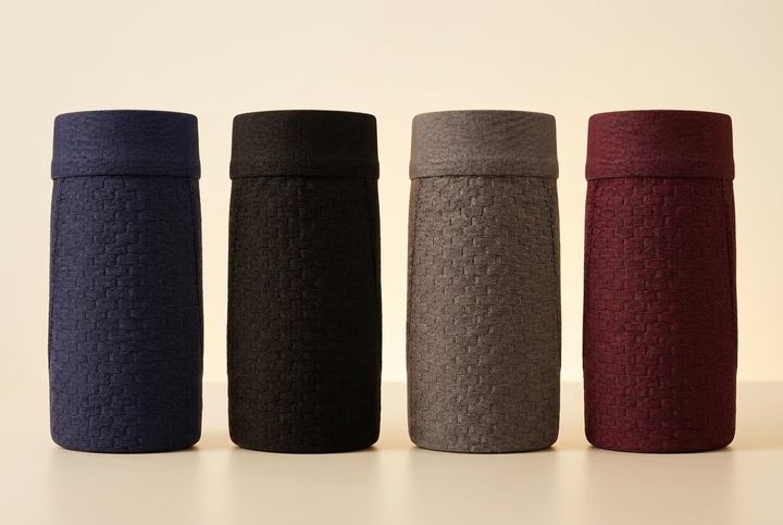 Four boxer briefs rolled into cylinders in navy, black, gray and burgundy, showing a woven brick-like texture 3