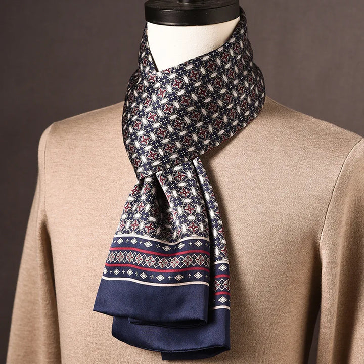 Navy silk scarf with a star and oval motif and a red-striped diamond border, draped on a mannequin over a tan sweater. 21