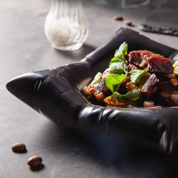 Black bowl detail with a glossy folded corner and ridged edge.