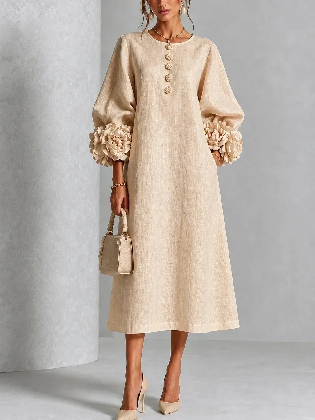 Model wears the light beige version of the midi dress with textured fabric, rose cuffs on the puffed sleeves and nude pumps. 3