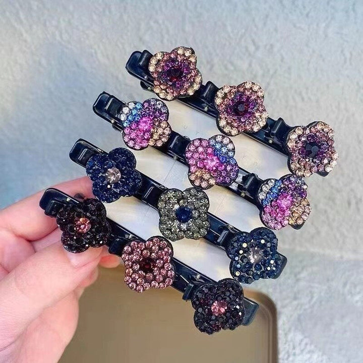 Four rhinestone flower hair clips in different color schemes, stacked in a hand against a textured wall 1