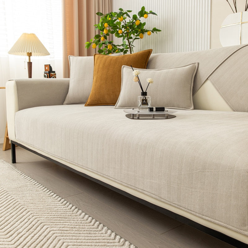 Light beige chenille sofa cover on a sofa with a mustard cushion and a tray holding a diffuser.