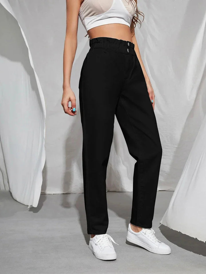 Frau in schwarzer Hose und weißem Top, weiße Sneaker, modisch, lässig, Damenbekleidung.