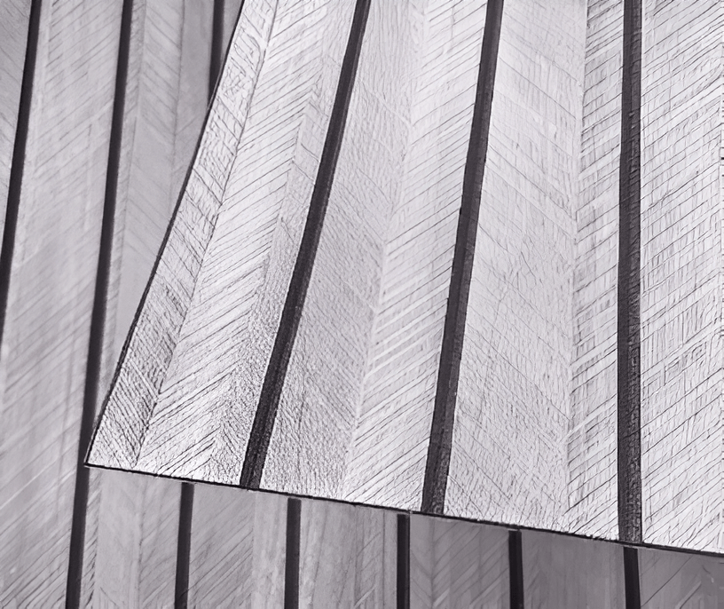 Self-adhesive wood panels in gray with a textured surface and a lifted corner.