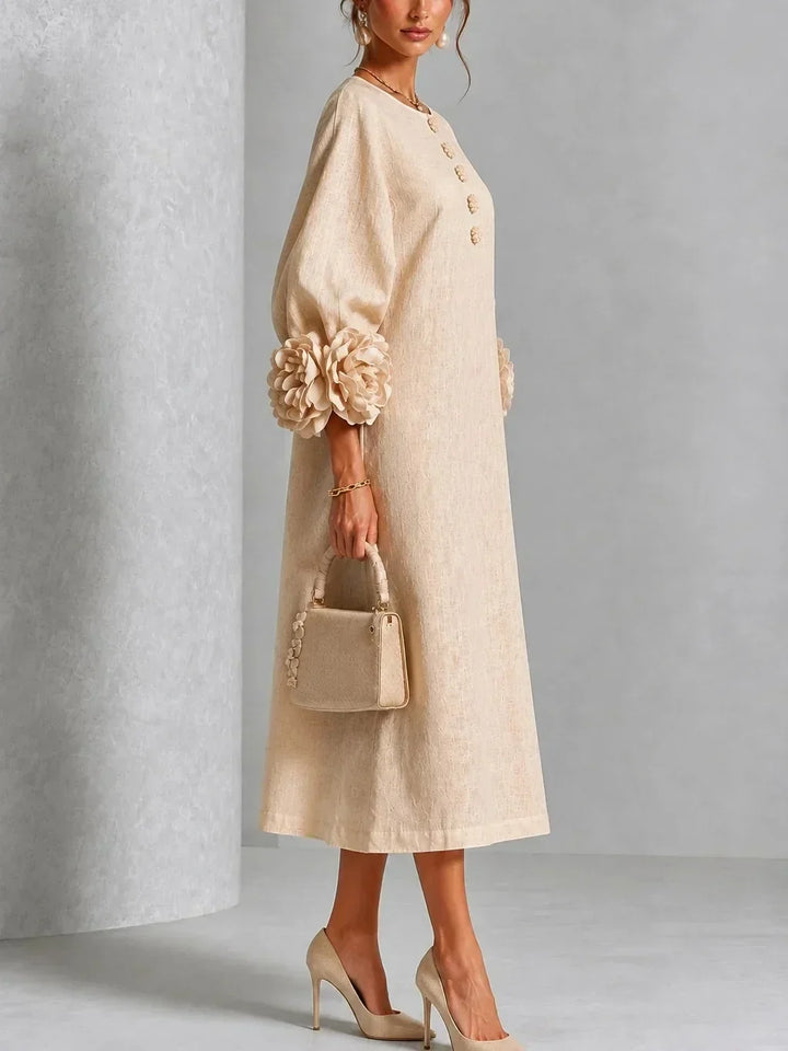 Side view of the beige midi dress on a model, showing the loose A-line fit, floral buttons and rose cuff detail. 8