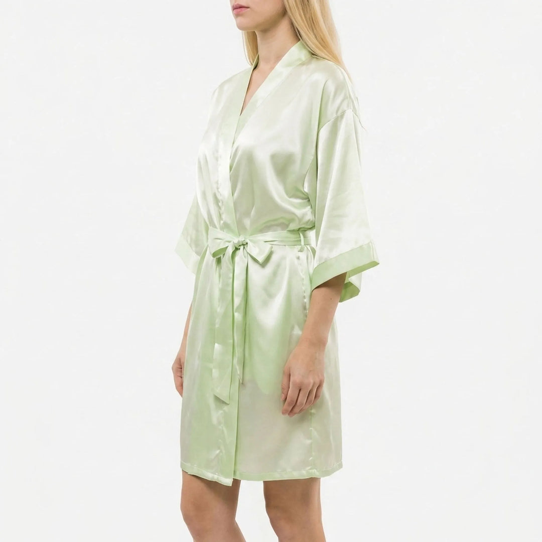 Side view of a model in the pale green satin robe, belt tied in a bow, with wide kimono sleeves and cuffs. 4