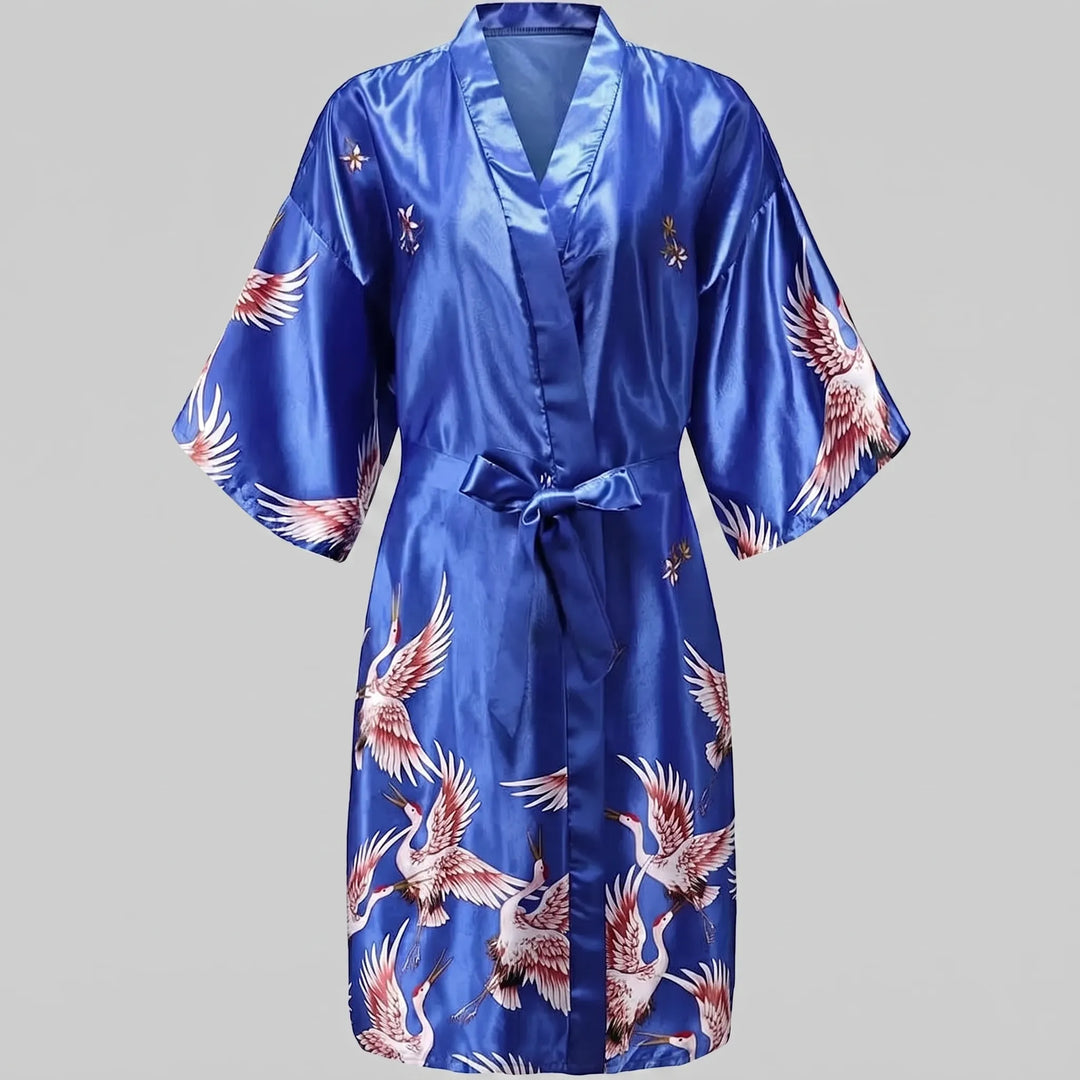 Royal blue satin version of the short kimono robe laid flat, with cranes on the sleeves and skirt and a tied belt. 11