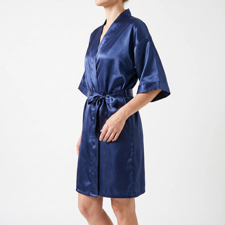 Side view of a model in the navy satin wrap robe, showing the V-neck, short wide sleeves and the belt bow at the waist. 4