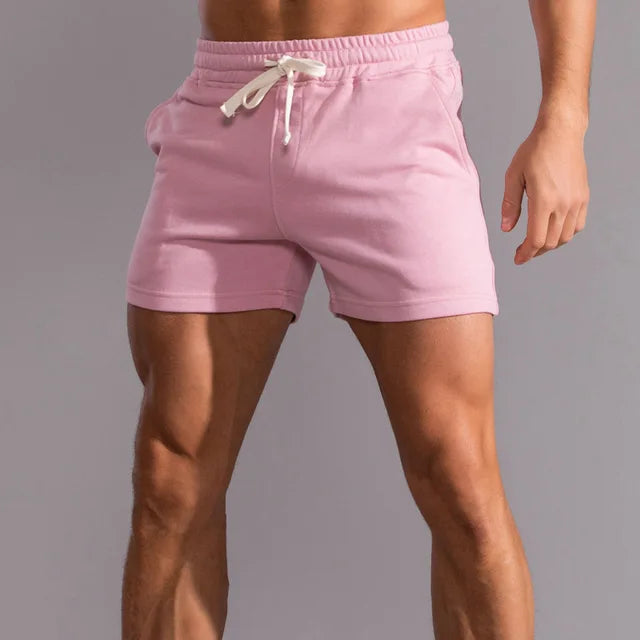 Pink men's athletic shorts with an elastic waistband and white drawstring.